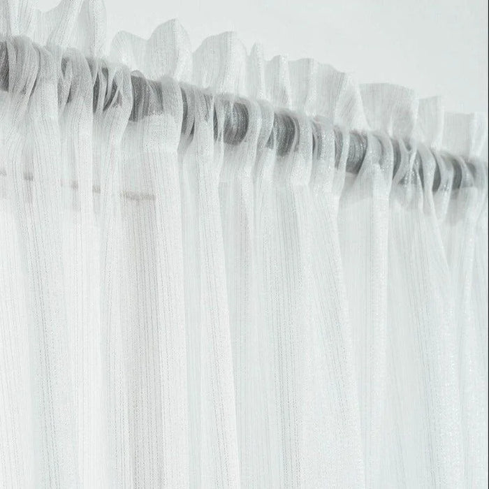 Voilage blanc délicat avec plis ondulés pour habillage de fenêtre, offrant une atmosphère lumineuse et élégante. Accessoire idéal pour une décoration intérieure moderne et épurée, parfait pour ajouter une touche de légèreté à n'importe quelle pièce.