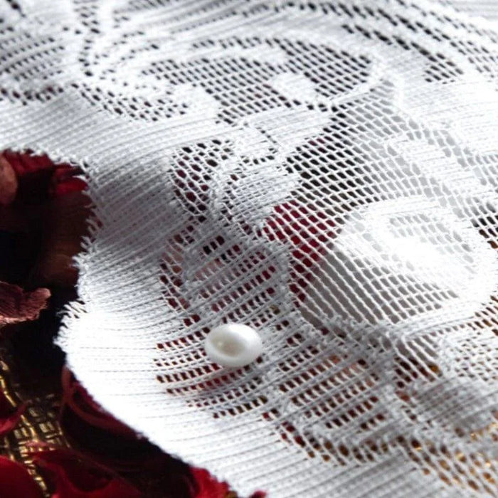 Détail d'un textile décoratif avec motif floral délicat et perle, idéal pour ajouter une touche élégante à votre décoration intérieure ou confectionner des accessoires de mode uniques.