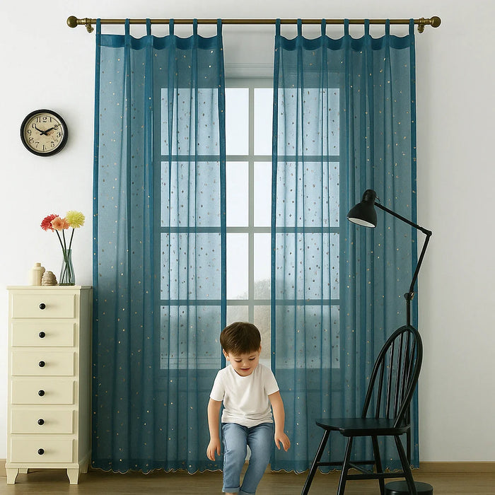 Voilage bleu translucide à motifs dorés installé dans une chambre d’enfant, avec un petit garçon au premier plan.