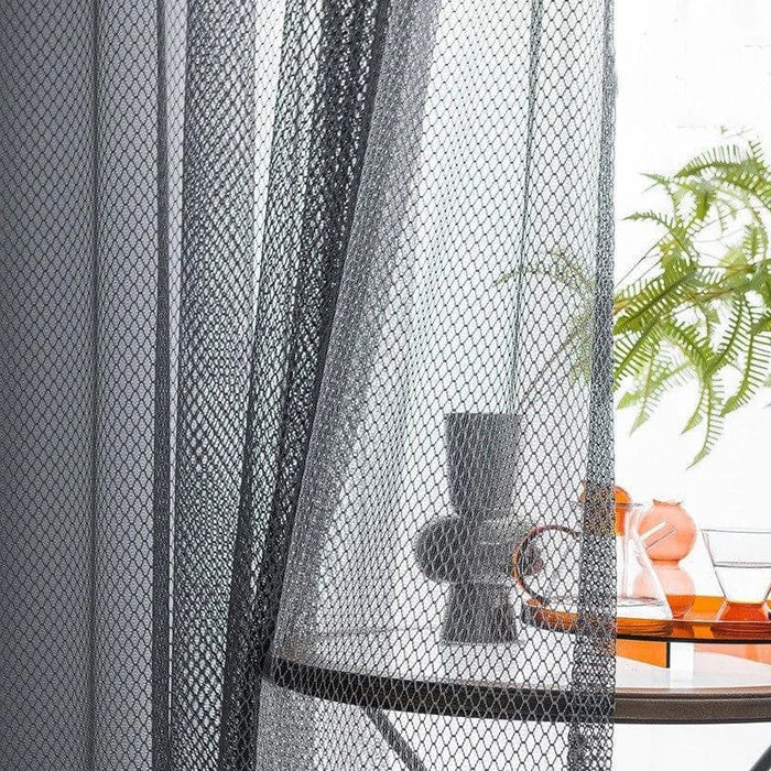 Voilage transparent noir pour salon moderne, ajout de texture et d'élégance, lumière naturelle tamisée, décoration d'intérieur contemporaine, ambiance raffinée et chaleureuse.