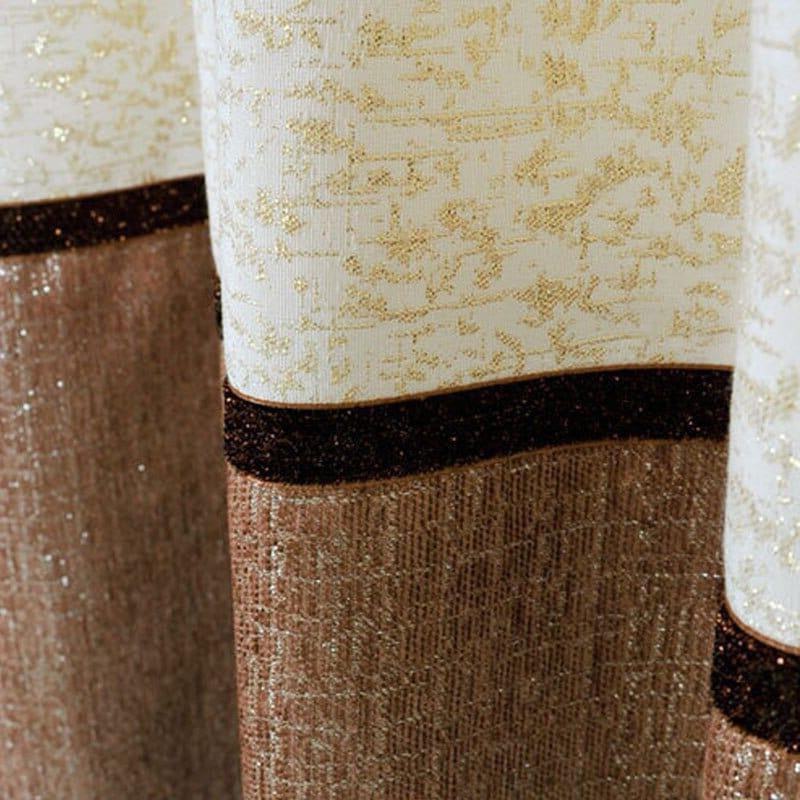 Rideau élégant aux motifs dorés et marrons, idéal pour ajouter une touche de sophistication à votre intérieur. Convient parfaitement pour un salon ou une chambre, apportant chaleur et raffinement à la décoration. Le contraste entre les teintes claires et sombres accentue l'élégance du produit.