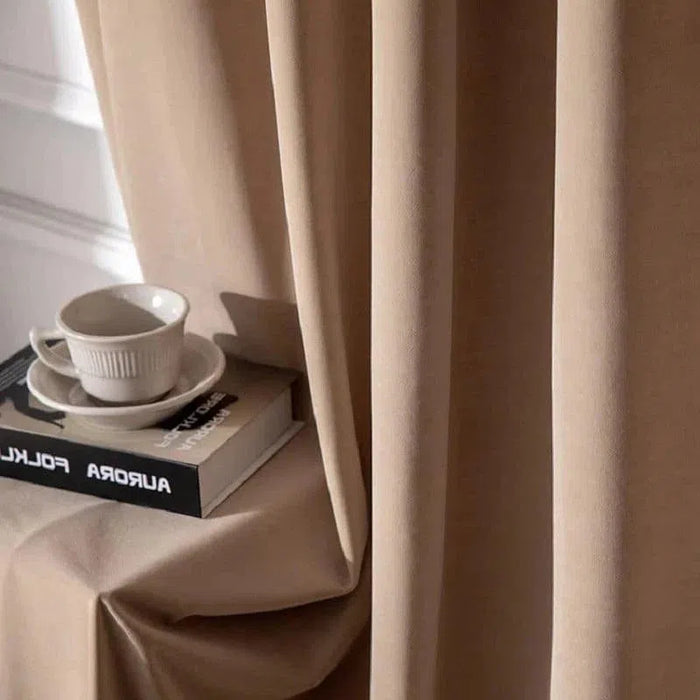 Rideau beige élégant pour salon moderne, idéal pour créer une atmosphère chaleureuse et accueillante. Accessoirisé avec une tasse à café et un livre, parfait pour un coin lecture cosy.