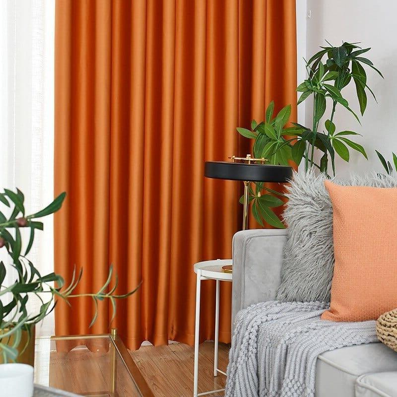 Rideau orange élégant pour salon moderne, ajoutant une touche vivante et chaleureuse à la décoration intérieure. Idéal pour créer une ambiance accueillante, associé à des plantes décoratives et un canapé avec coussins assortis. Parfait pour un intérieur contemporain et stylé.