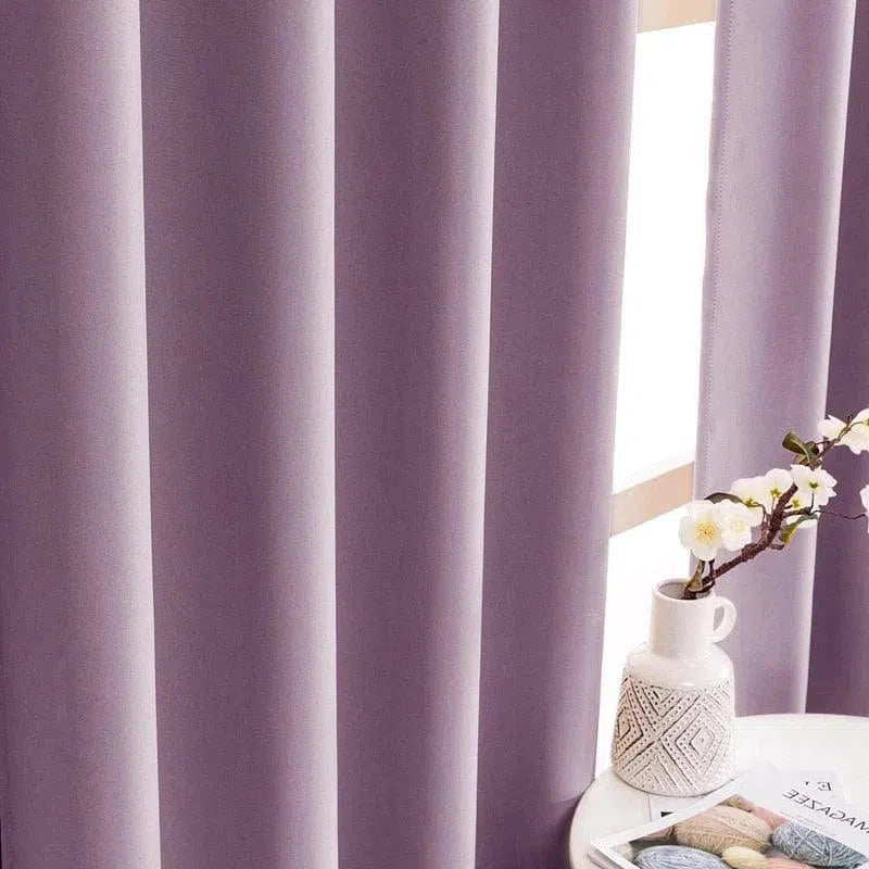 Rideau violet élégant dans un intérieur moderne, associé à une table blanche avec vase floral, idéal pour une ambiance apaisante et raffinée.