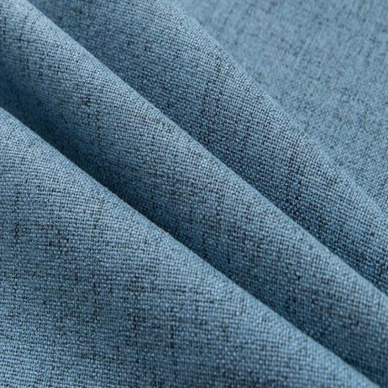 Image d'un textile bleu à motifs finement tissés, idéal pour la décoration intérieure, avec des plis mettant en valeur la texture du tissu. Parfait pour confectionner des rideaux, des housses de coussin ou des projets créatifs en design d'intérieur.