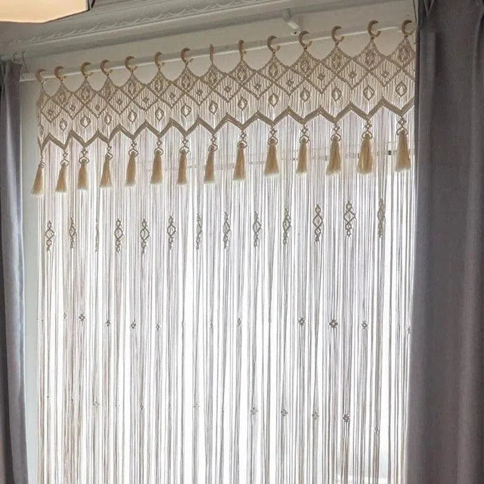 Rideau macramé blanc élégant avec franges longues, motifs géométriques et ornements suspendus, idéal pour une décoration bohème et raffinée de salon ou de chambre, laissé translucide pour maximiser la lumière naturelle tout en préservant l'intimité.