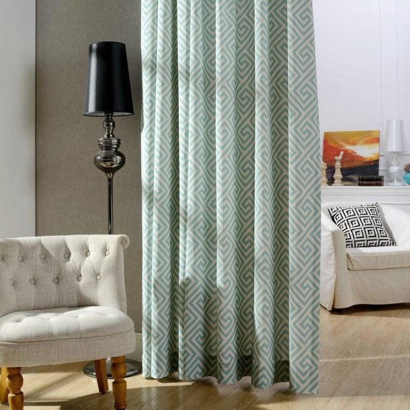 Rideau moderne avec motif géométrique dans un intérieur élégant, accompagné d'un fauteuil confortable et d'une lampe design, idéal pour sublimer votre salon.