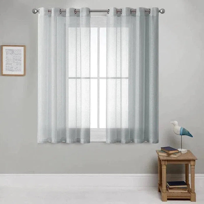 Rideaux transparents gris clair avec anneaux métalliques suspendus dans un salon moderne. Ce modèle élégant crée une ambiance lumineuse et aérée, parfait pour la décoration intérieure. Accessoire idéal pour habiller les fenêtres tout en laissant passer la lumière naturelle, ajoutant une touche de sophistication à votre espace de vie.