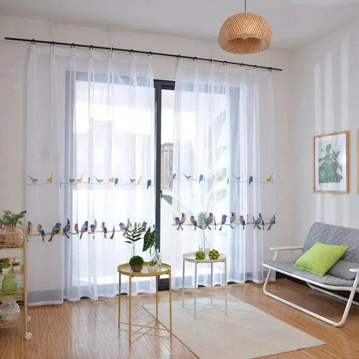 Rideau transparent blanc avec motifs d'oiseaux colorés, idéal pour ajouter une touche de nature et d'élégance à votre salon. Crée une ambiance lumineuse et aérée, parfait pour les espaces de vie modernes et accueillants. Accessoire décoratif tendance pour habiller une grande fenêtre ou une baie vitrée.