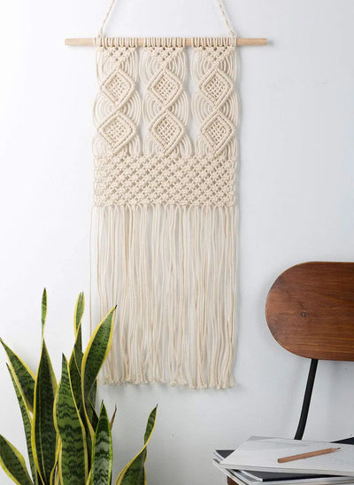 Tapisserie murale macramé beige sur mur blanc