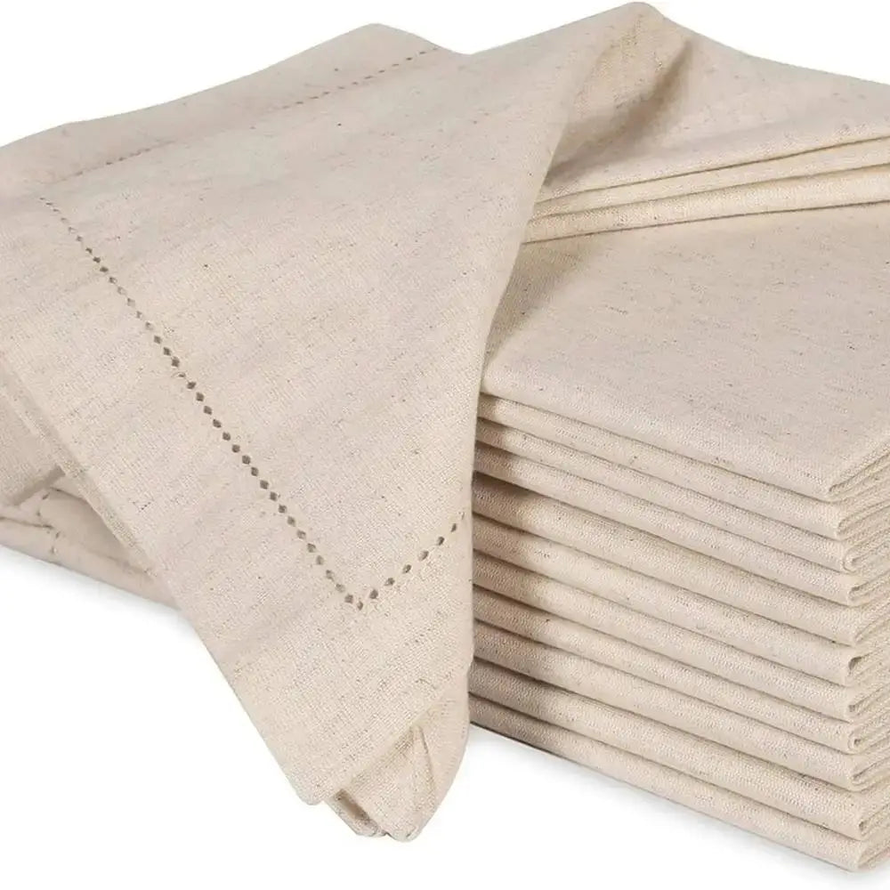 Pile de serviettes de table en lin beige, avec des points de couture élégants.