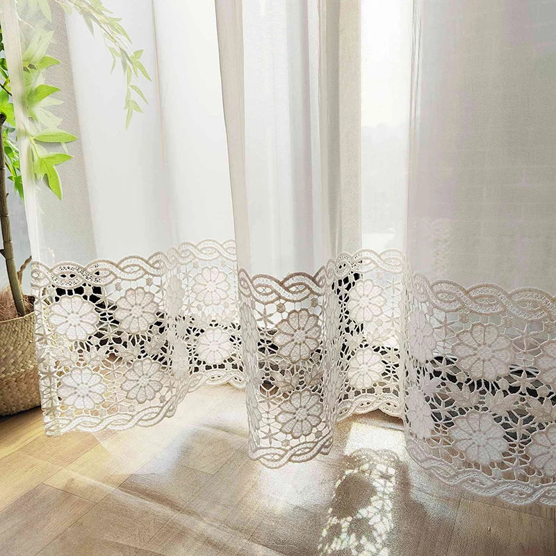 Voilage ajouré capturant la lumière du jour, avec une finition florale en bas et reflet de lumière douce au sol.