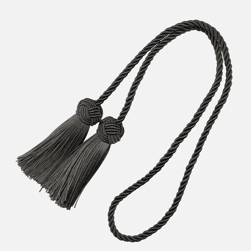 Embrasse rideau noire en corde torsadée avec deux pompons, parfaite pour une ambiance chic et contemporaine.