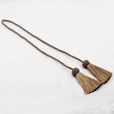Embrasse rideau en polyester torsadé avec pompons marron foncé, idéale pour une décoration chaleureuse et élégante.