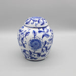 Un pot en céramique décoré de motifs floraux bleus et blancs, avec un couvercle assorti, offrant un bel élément de décoration pour un intérieur.