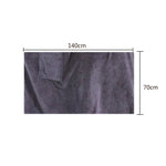 Serviette de bain microfibre noire pliée avec des accessoires de salle de bain