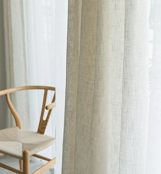 Image d'élégants rideaux en aspect lin, un matériau naturel, suspendus à une fenêtre. Ces textiles tissés présentent une couleur argentée unique, ajoutant une touche de sophistication à tous les traitements de fenêtre. Ces rideaux, synonymes de qualité et d'élégance, sont le choix parfait pour tout décor de maison soucieux de son style.
