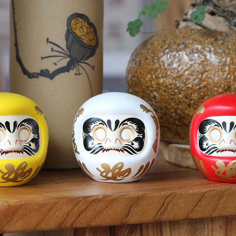 statuette japonaise daruma rouge blanche visage sourire motifs dorés traditionnels feng shui ornement chance
