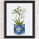 Une magnifique composition florale blanche dans un élégant pot décoratif bleu avec des fleurs stylisées.