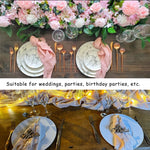 Cette image montre une élégante table de fête décorée de fleurs roses, de vaisselle en marbre et d'accessoires dorés, convenant parfaitement pour des célébrations telles que des mariages, des anniversaires ou d'autres événements spéciaux.
