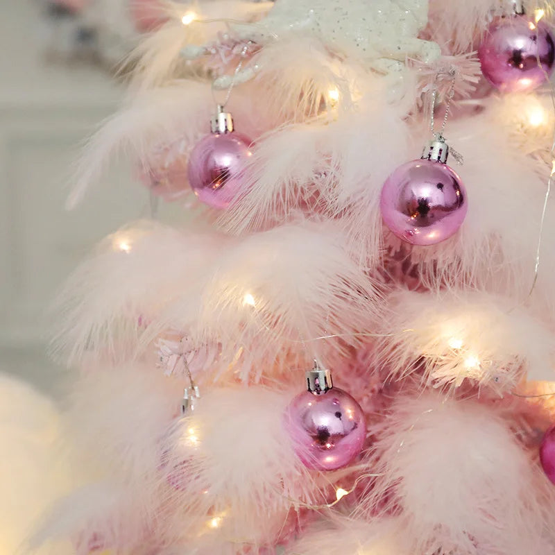 Détail des plumes roses et des ornements bleus du mini arbre de Noël