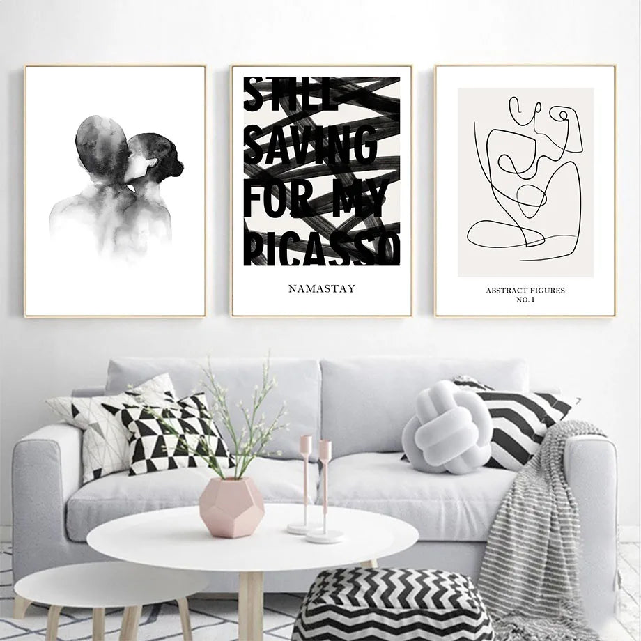 Dans cette image, on voit un salon moderne avec des œuvres d'art aux murs représentant des silhouettes humaines et des figures abstraites, ainsi que des accessoires décoratifs monochromes.