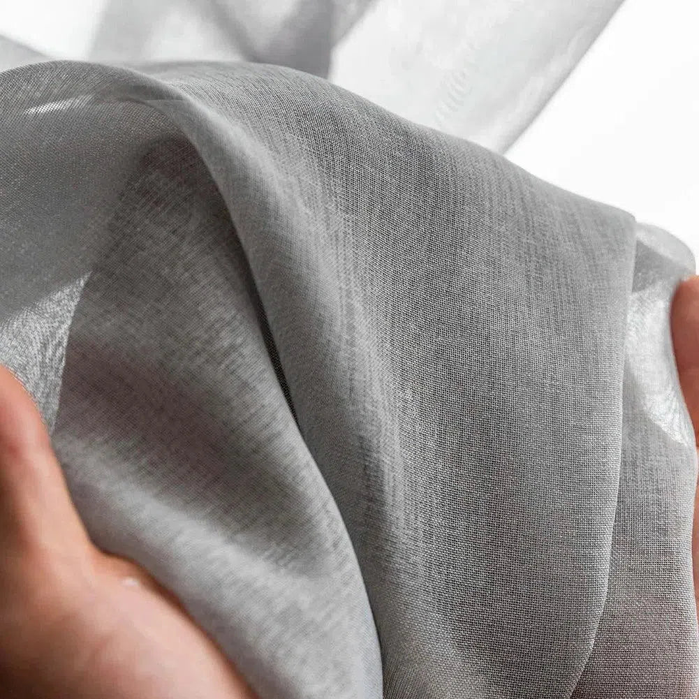 Drapé élégant en gris clair tenu à la main, idéal pour un usage décoratif ou vestimentaire. Découvrez la délicatesse et la légèreté de ce tissu polyvalent, parfait pour ajouter une touche de sophistication à vos créations.