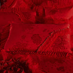 Parure de lit rouge dans une chambre décorée avec des accessoires en or