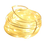 Guirlande LED extérieure blanche décorant un jardin la nuit