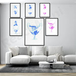 Ensemble de peintures murales abstraites bleues et roses sur un mur blanc, avec un canapé blanc et une table basse en marbre dans un intérieur moderne.