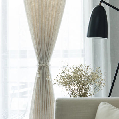 Voilage effet lin naturel noué élégamment au centre, laissant passer la lumière dans un salon lumineux à la décoration épurée.