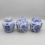 Trois bocaux en porcelaine bleu et blanc ornés de motifs floraux et de symboles traditionnels chinois.