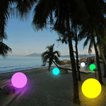 Boule lumineuse verte dans un bassin extérieur avec reflets