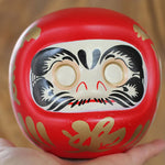 statuette japonaise daruma rouge blanche visage sourire motifs dorés traditionnels feng shui ornement chance