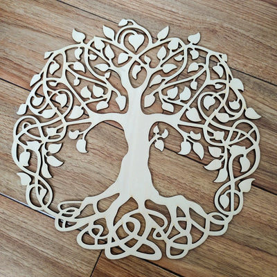 Arbre de vie en bois découpé au laser suspendu sur un mur blanc