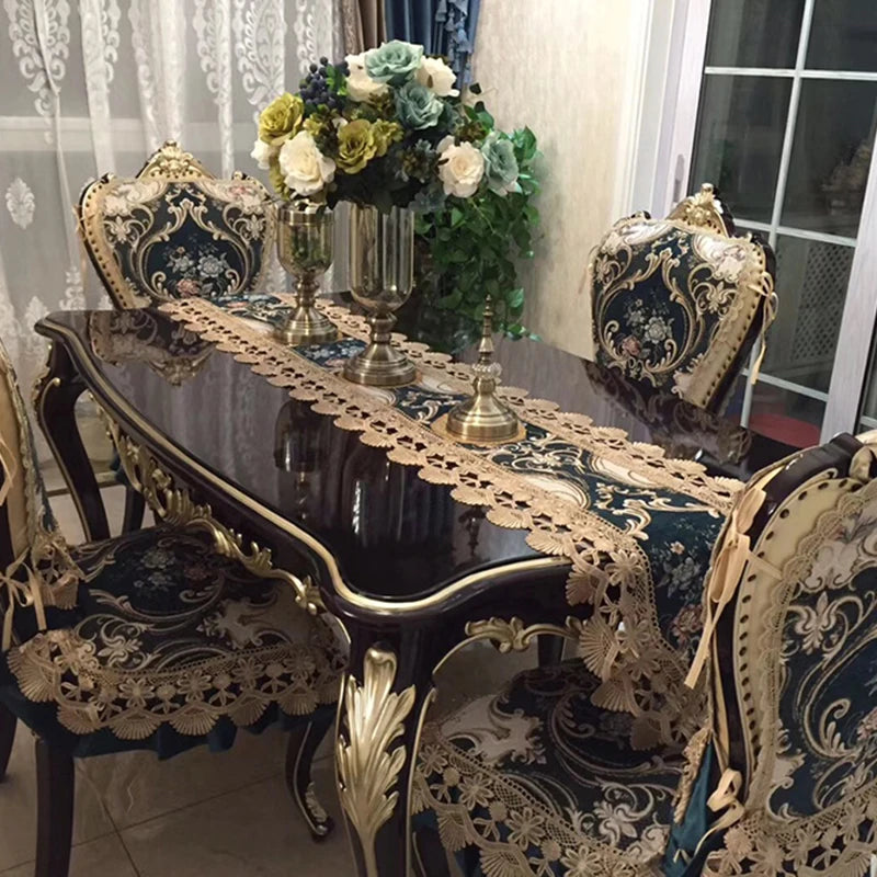 Salle à manger élégante avec une table ornée de nappes et de décorations florales, entourée de chaises sculptées dans un style classique.