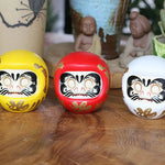 statuette japonaise daruma rouge blanche visage sourire motifs dorés traditionnels feng shui ornement chance