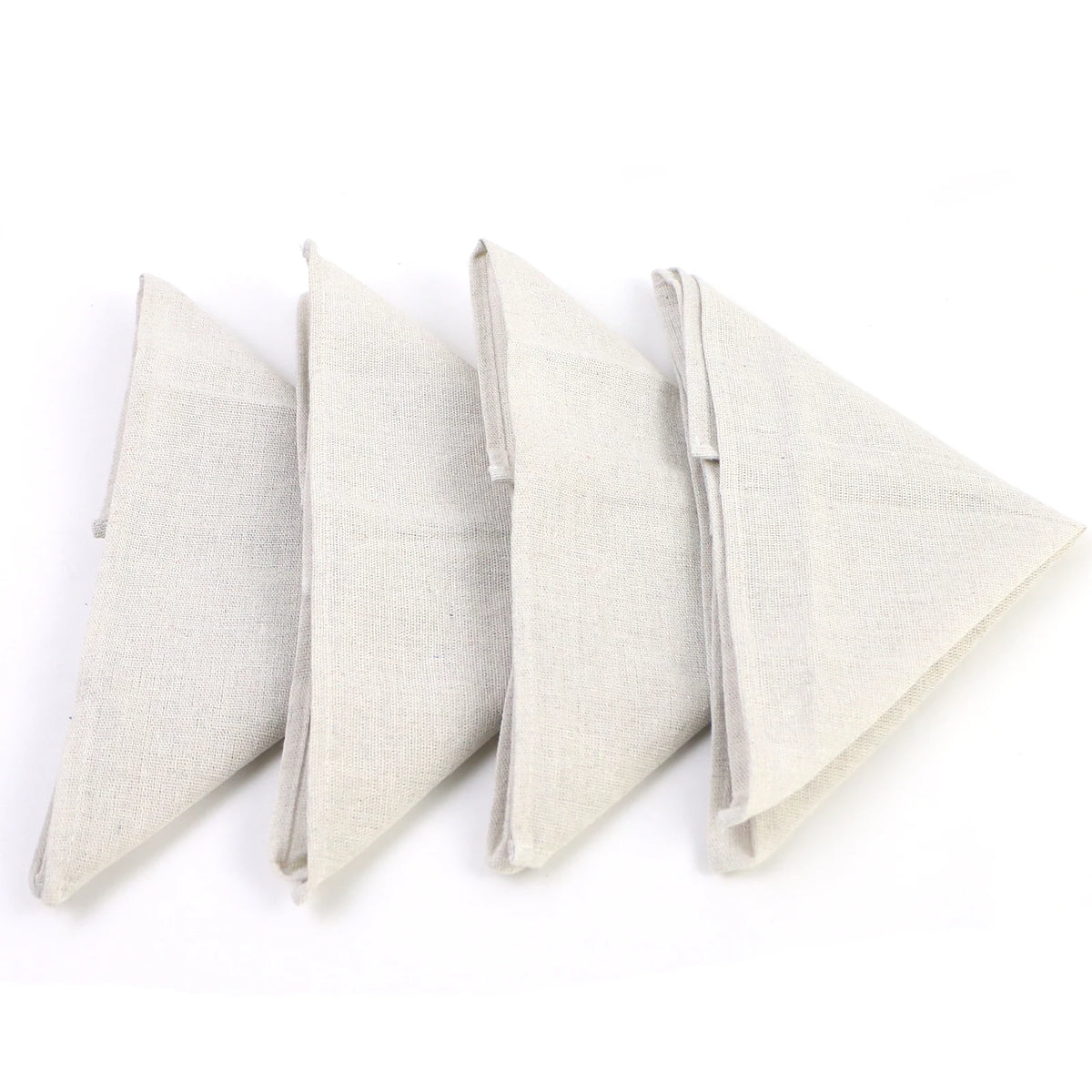 Quatre serviettes de table élégantes en lin blanc, pliées avec soin.