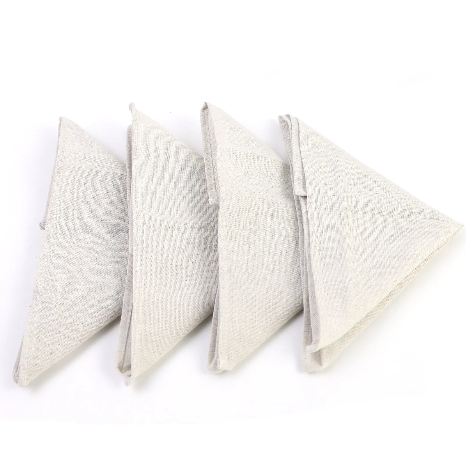 Quatre serviettes de table élégantes en lin blanc, pliées avec soin.
