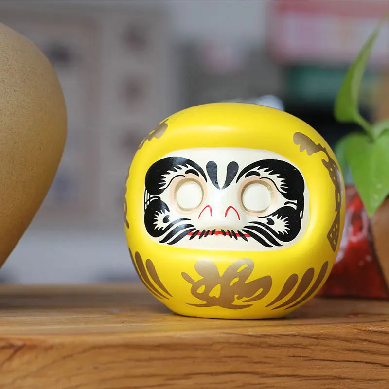 statuette japonaise daruma rouge blanche visage sourire motifs dorés traditionnels feng shui ornement chance