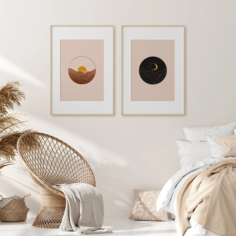 Deux illustrations encadrées représentant le paysage du soleil et de la lune sur un fond de couleurs neutres, créant une atmosphère sereine et apaisante dans cette chambre à coucher.
