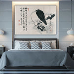 L'image montre une chambre à coucher avec un cadre mural présentant une illustration asiatique en noir et blanc d'un oiseau noir perché sur une branche.