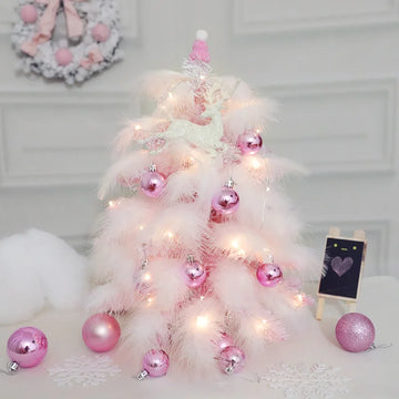 Sapin de Noël en plumes roses de 45cm avec décorations bleues sur table en bois