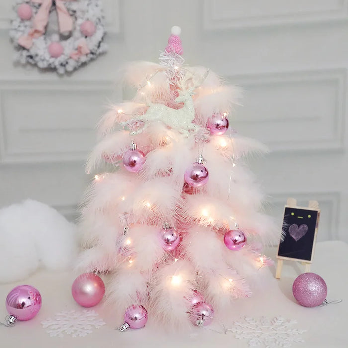 Sapin de Noël en plumes roses de 45cm avec décorations bleues sur table en bois