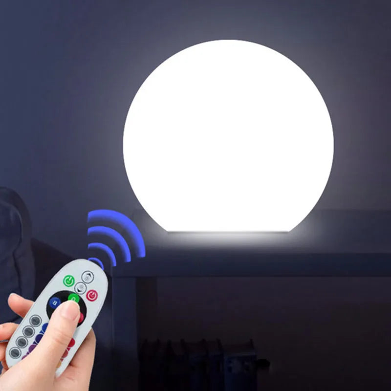Sphère lumineuse LED multicolore près d'une piscine
