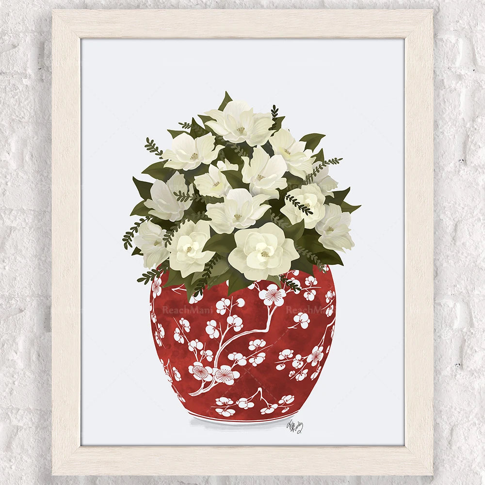 Un vase en porcelaine rouge orné de fleurs blanches et de feuilles vertes, disposées avec élégance pour créer une composition florale harmonieuse.