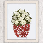 Un vase en porcelaine rouge orné de fleurs blanches et de feuilles vertes, disposées avec élégance pour créer une composition florale harmonieuse.