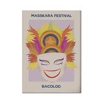 Affiche colorée du festival Masskara mettant en vedette un masque souriant sur un fond de feuilles d'automne et de flammes.