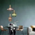 Lampe pendentif en verre coloré installée dans un salon