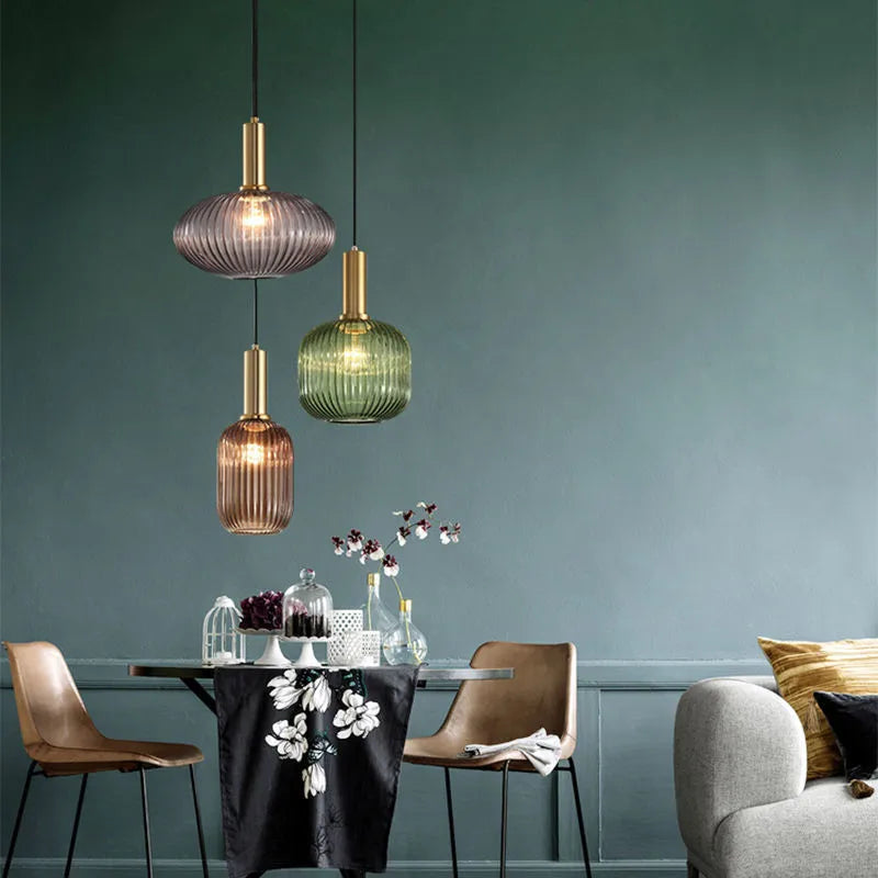 Lampe pendentif en verre coloré installée dans un salon